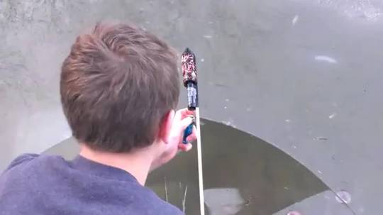 A firework exploding under a frozen pond.