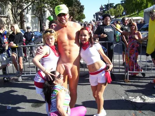 Hung white man posing nude with women in costumes at Bay to Breakers street fair, CFNM public exhibitionism