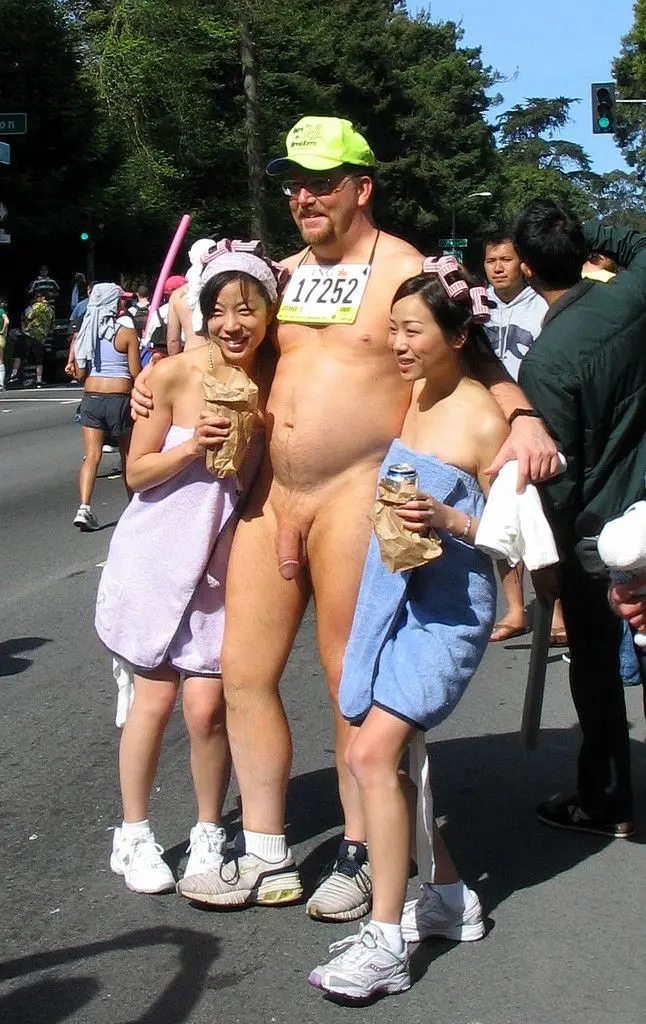 Hung white man posing nude with women in costumes at Bay to Breakers street fair, CFNM public exhibitionism