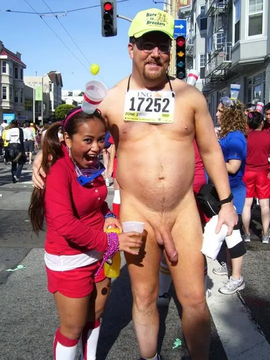 Hung white man posing nude with women in costumes at Bay to Breakers street fair, CFNM public exhibitionism
