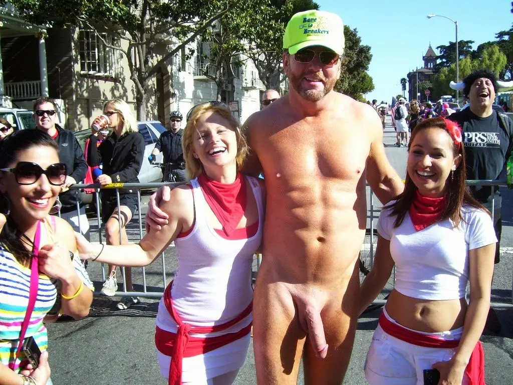 Hung white man posing nude with women in costumes at Bay to Breakers street fair, CFNM public exhibitionism