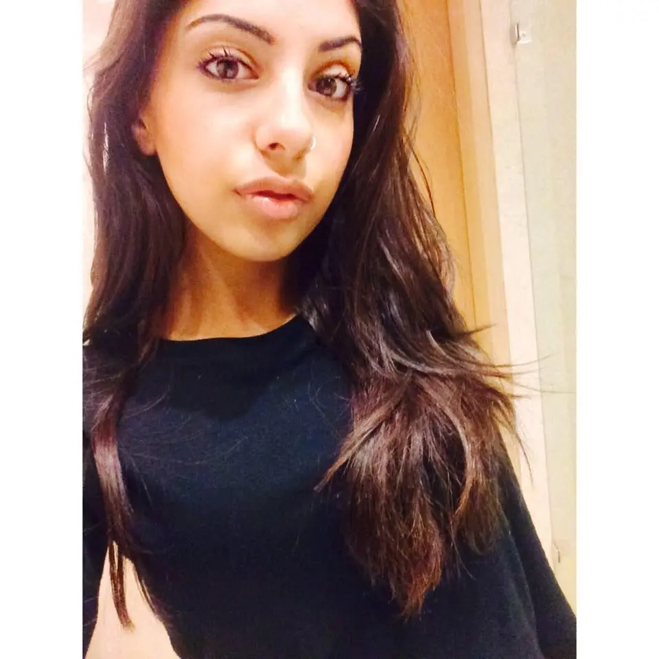 Mixed race desi girl with a nose ring posing for selfies, both clothed in a black t-shirt and naked.
