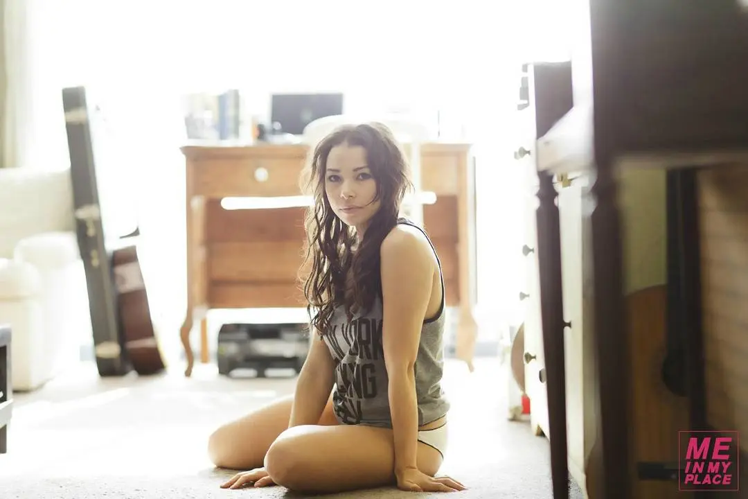 Jessica Parker Kenney in tank tops and denim shorts posing in a New York City living room and bathroom