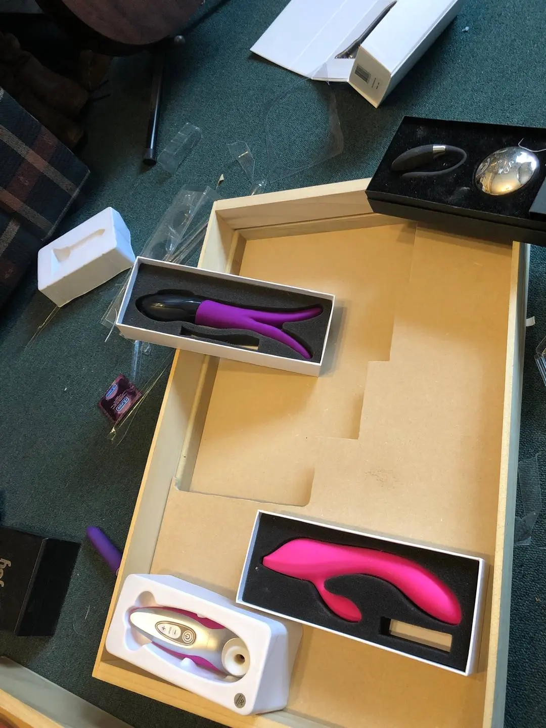 Sex toys including dildos, vibrators, and anal beads organized in a wooden dresser drawer