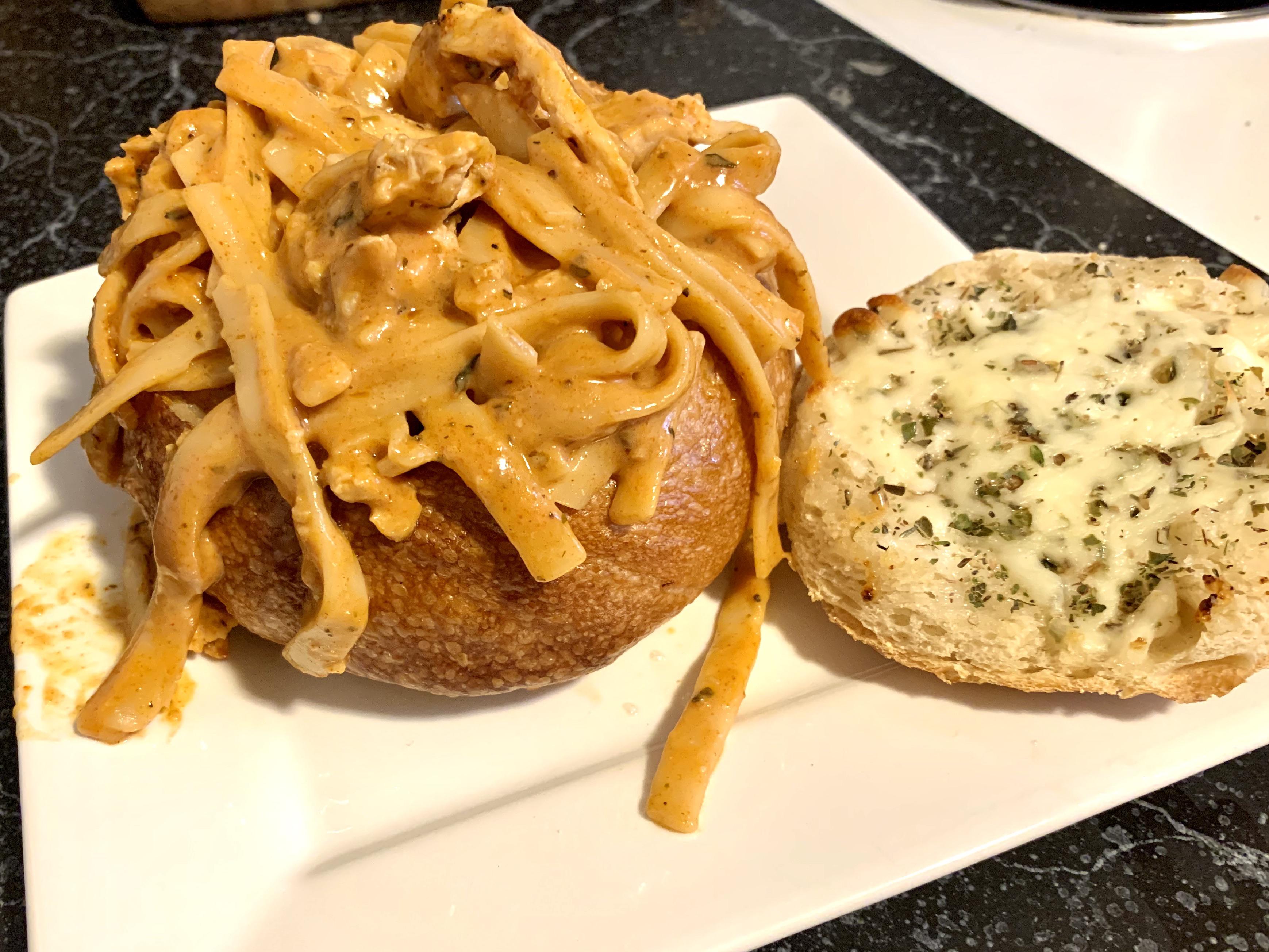 Sourdough bread bowl with Cajun chicken alfredo. Made cheesy garlic
