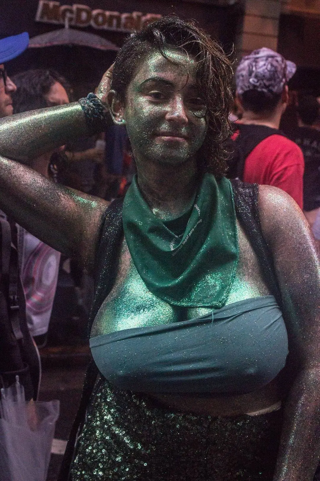 Athletic brunette woman in green goblin cosplay with body paint and glittery outfit