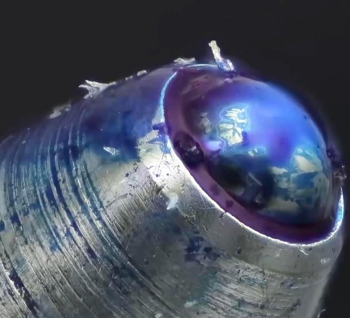 The tip of a ballpoint pen under a microscope Scrolller