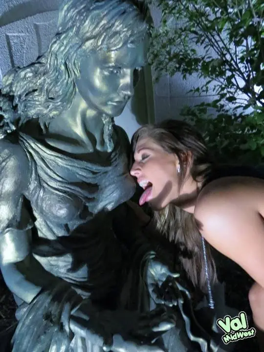 Val theWoo in a blue mini dress posing topless and lying in a garden planter at night