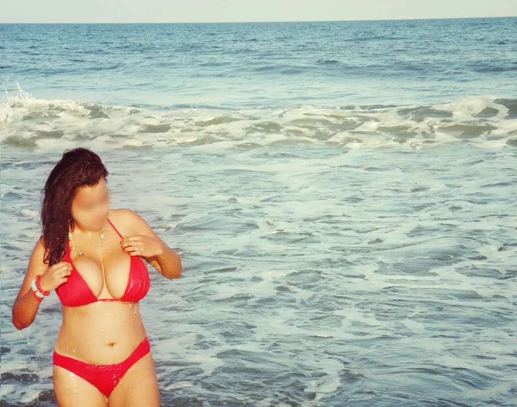 Curvy Indian bhabhi in a red bikini and turquoise sarong posing on a sandy beach