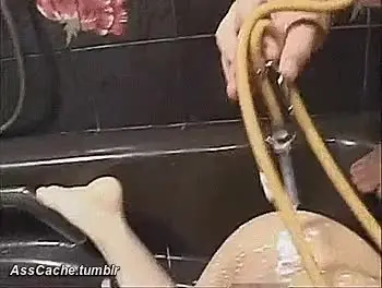 Curvy Asian woman in a bathtub receiving an enema and anal squirt with milk