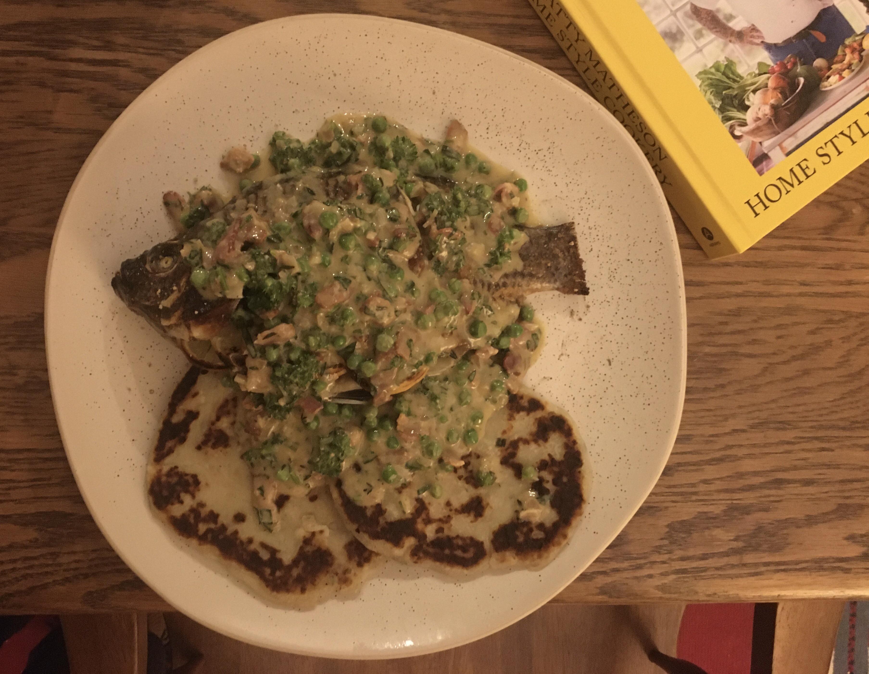 Baked whole tilapia covered in a sauce with Dijon bacon peas parsley