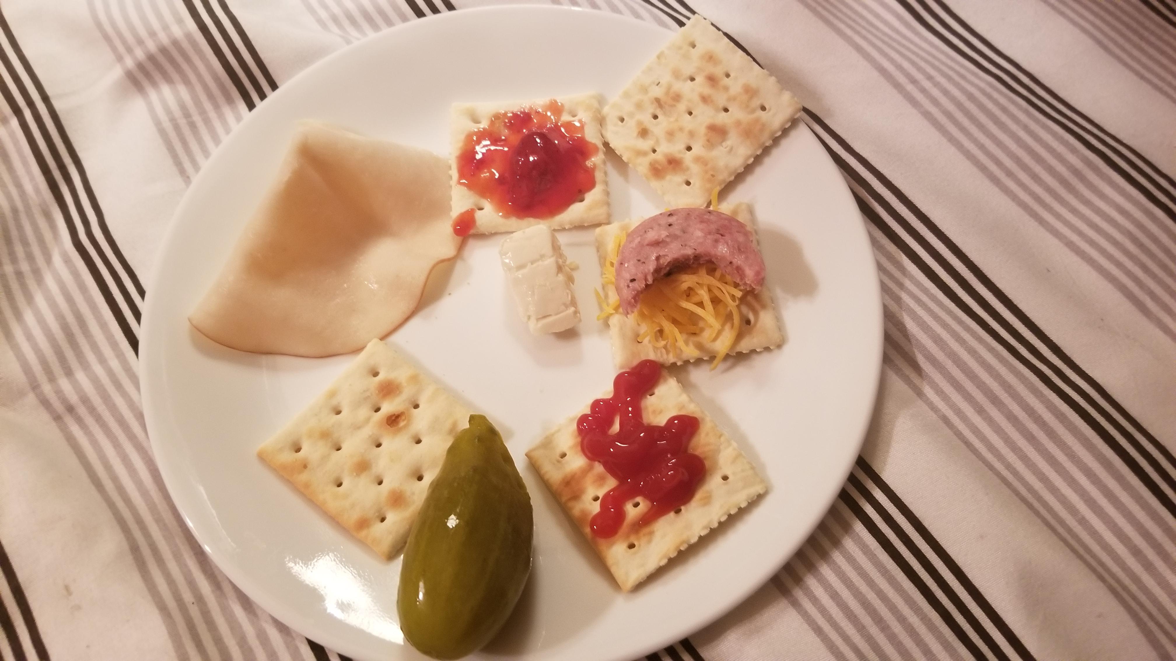 crackers with various toppings, a pickle, and Turkey. . who needs to