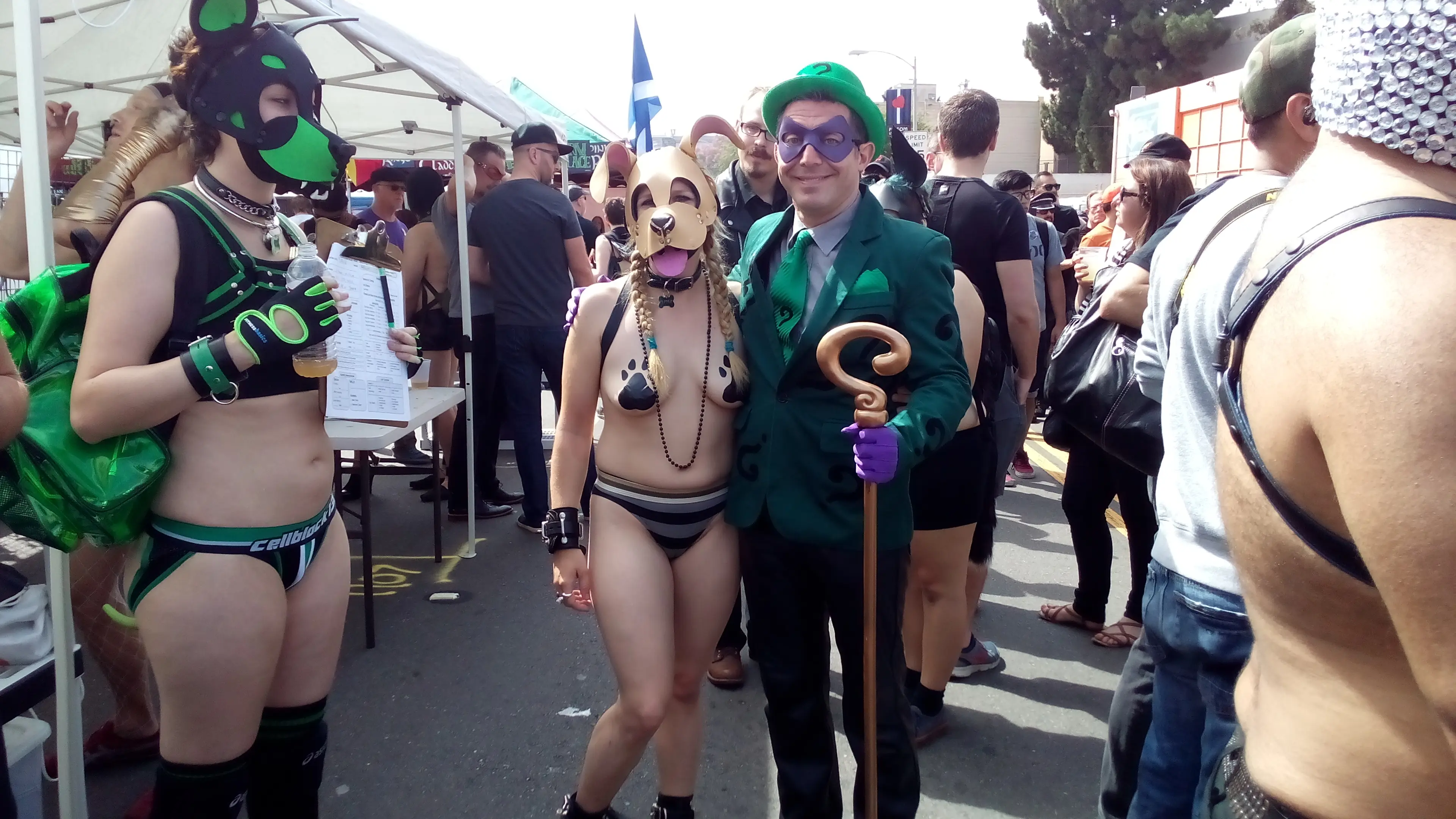 Kato and Pepper in pup play gear and masks at the Folsom Street Fair, including a man in a tiger costume.