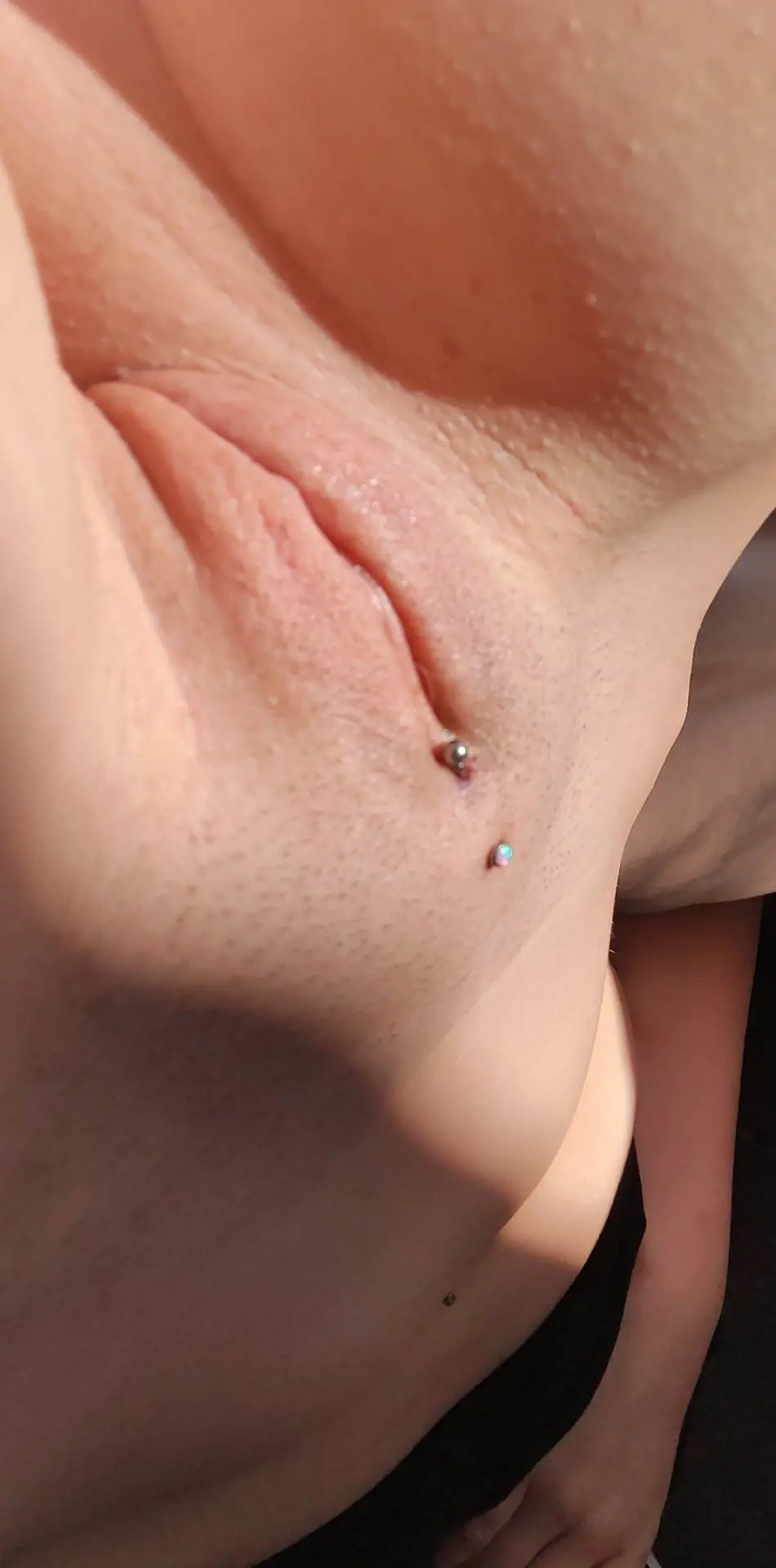 Close-up selfie of a slim white woman's vulva featuring a Christina piercing