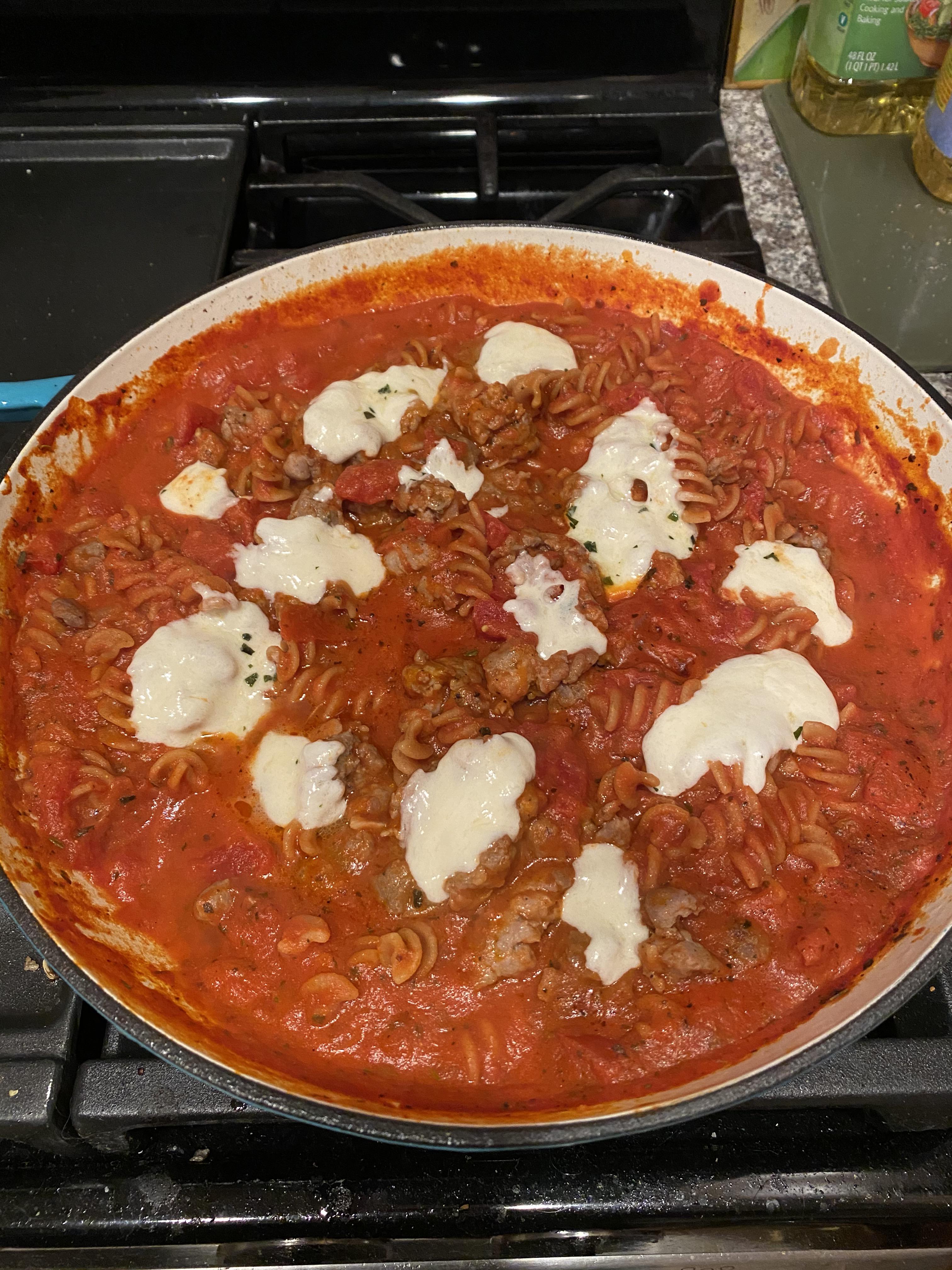 Fusilli pasta with sausage in marinara and topped with mozzarella Scrolller