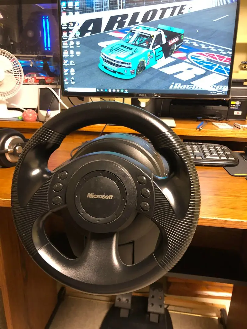 Close-up of a Microsoft racing wheel controller and DELL monitor for iRacing on a gaming pc desk setup