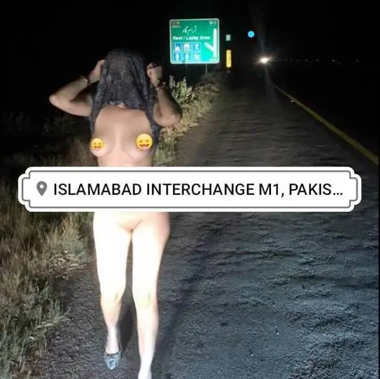 Pakistani wife flashing on a roadside at night, slim woman with long dark hair standing with hands on head