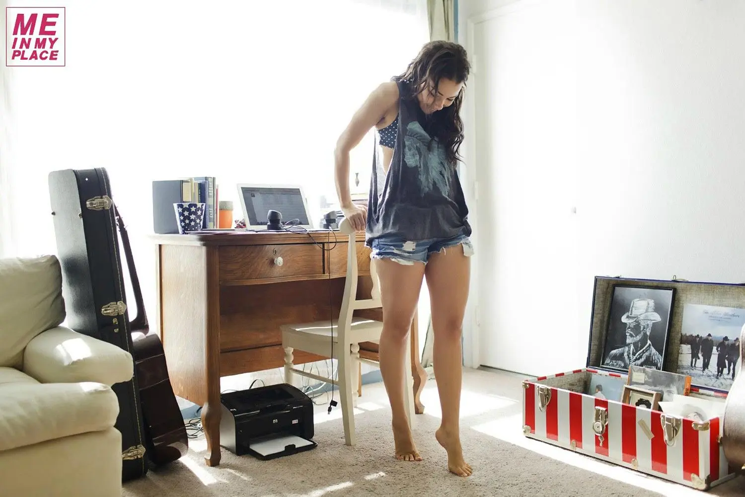 Jessica Parker Kenney in tank tops and denim shorts posing in a New York City living room and bathroom