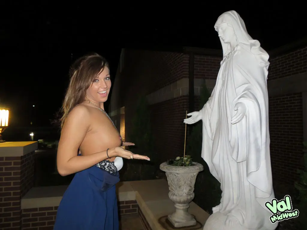 Val theWoo in a blue mini dress posing topless and lying in a garden planter at night