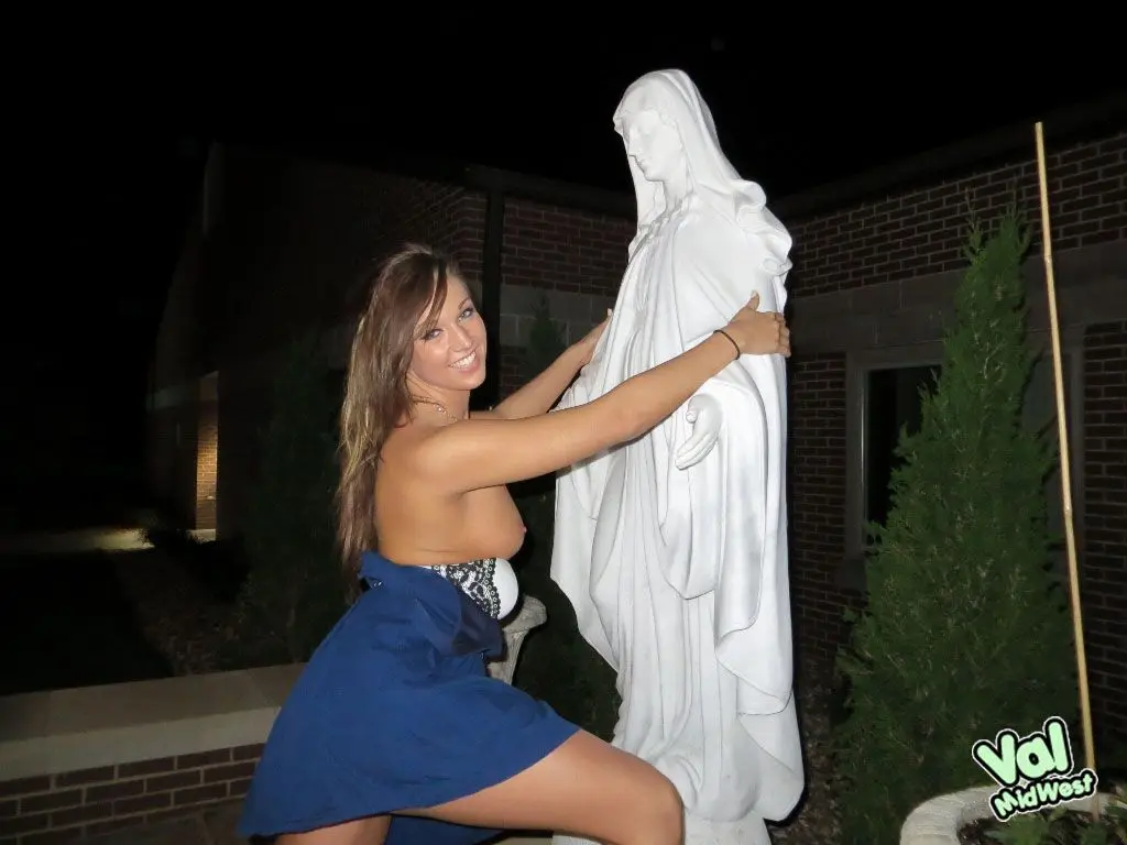 Val theWoo in a blue mini dress posing topless and lying in a garden planter at night