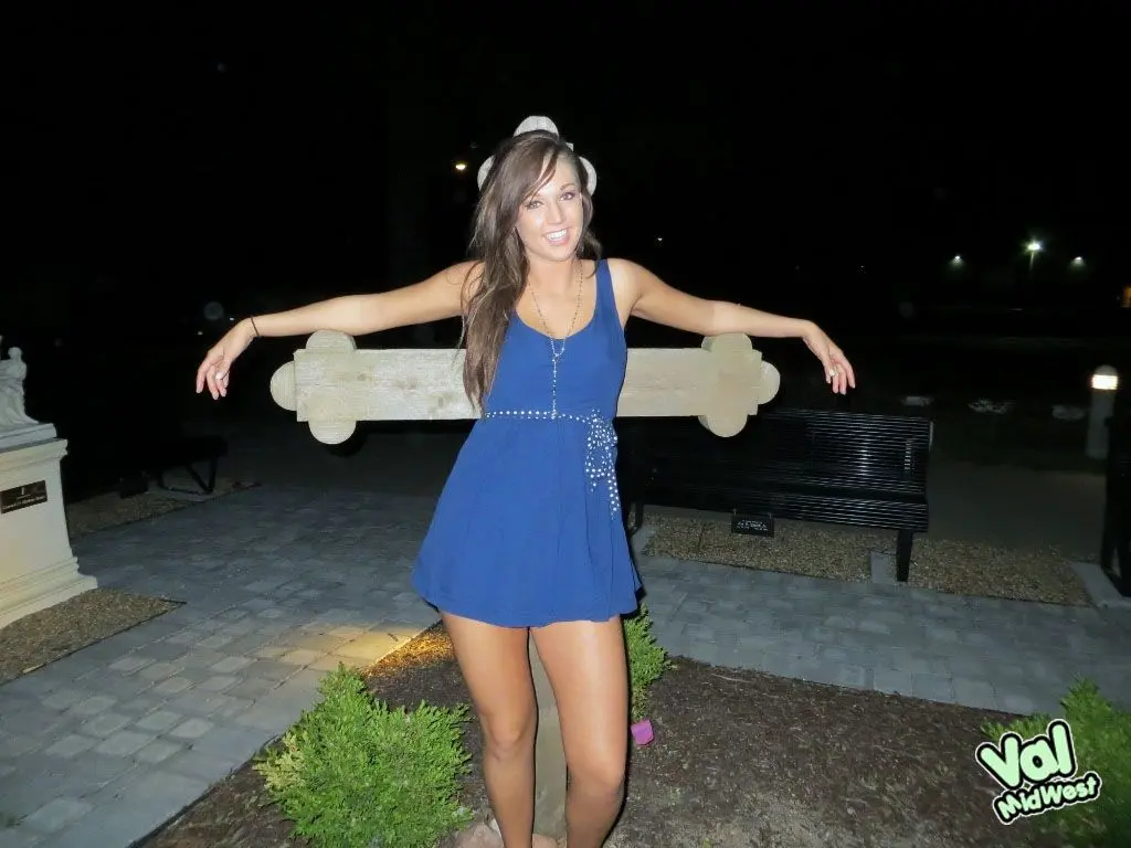 Val theWoo in a blue mini dress posing topless and lying in a garden planter at night