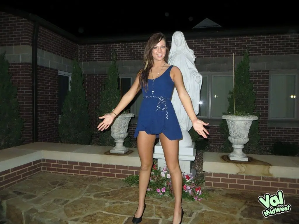 Val theWoo in a blue mini dress posing topless and lying in a garden planter at night