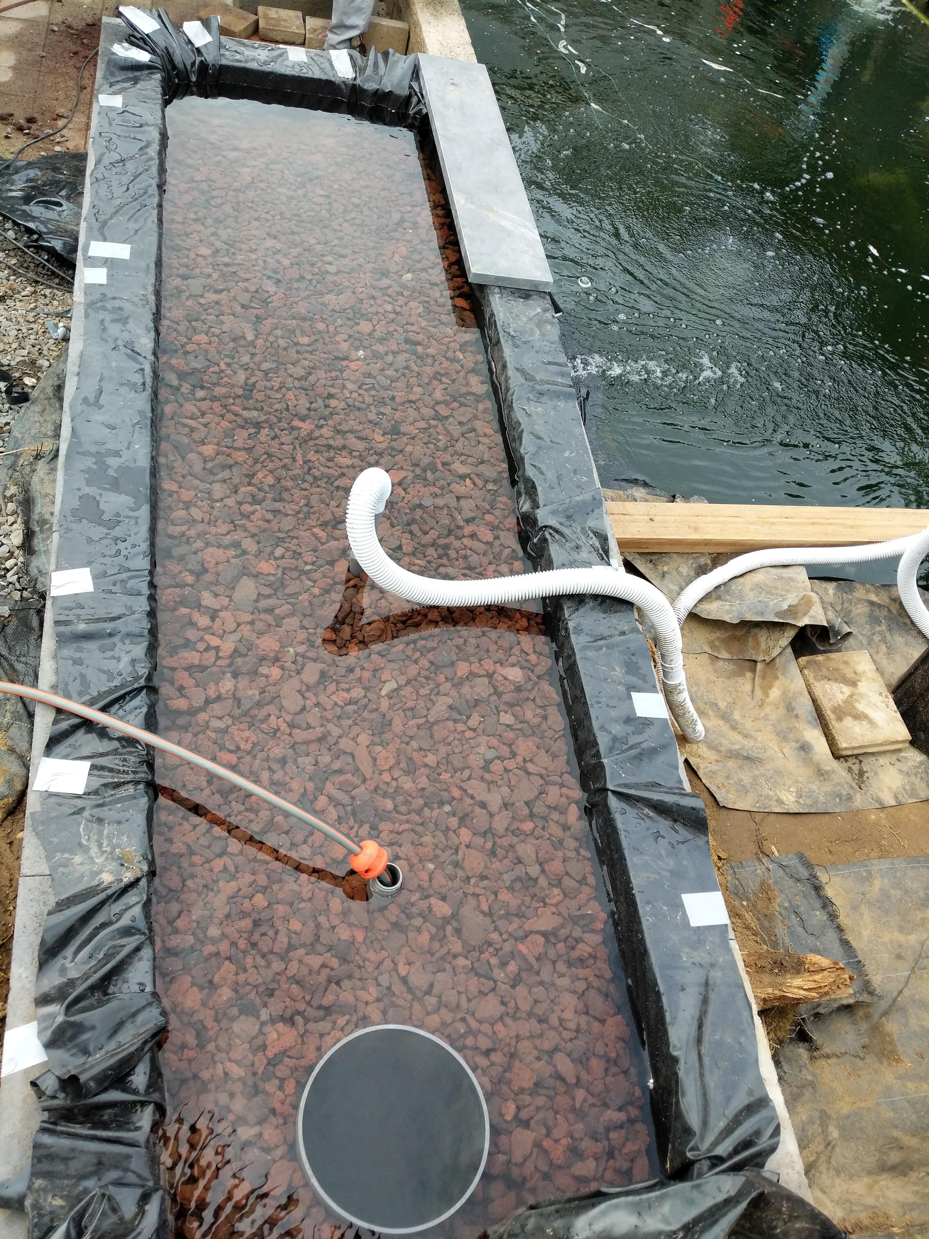 Building a natural filter with my dad. Filled with lava rock, next up ...