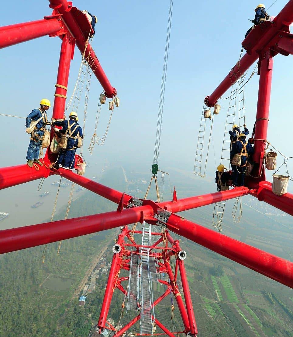 Chinese power workers at 270 meters installing one of 1,421 crossing towers for high voltage lines from Huainan to Shanghai
