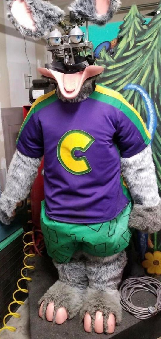 Chuck E. Cheese bot with most of his face cosmetics missing.