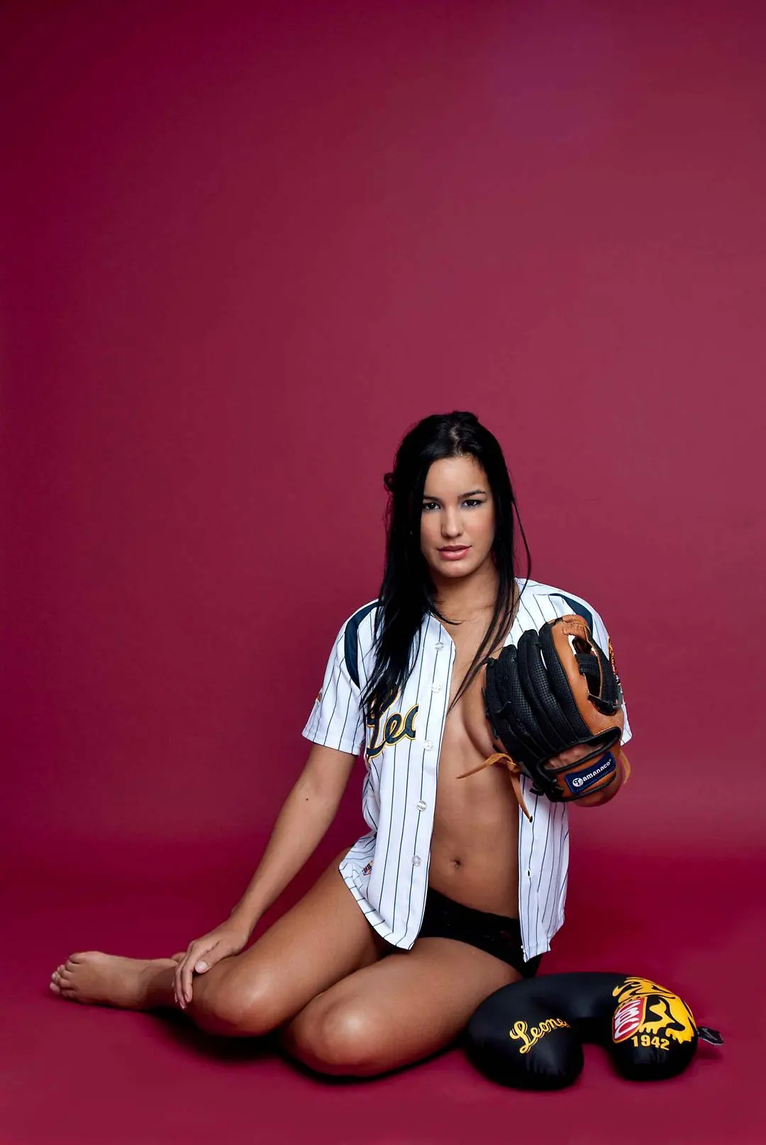 Edmar Leal posing in a baseball jersey, bra, and panties with a bat and glove in a studio