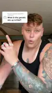Elizabeth Fort Knox, a muscular woman with extensive colorful tattoos and a black tank top, laughing in a TikTok video.