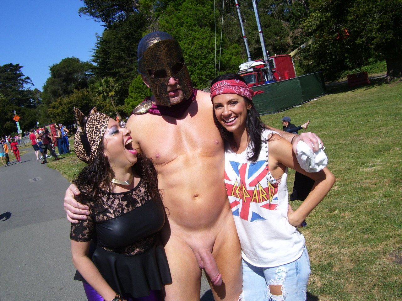 Hung white man posing nude with women in costumes at Bay to Breakers street fair, CFNM public exhibitionism
