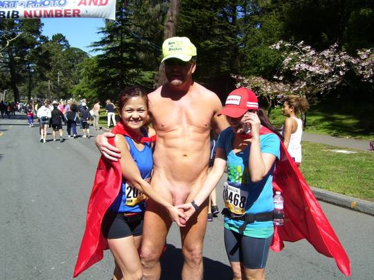 Hung white man posing nude with women in costumes at Bay to Breakers street fair, CFNM public exhibitionism