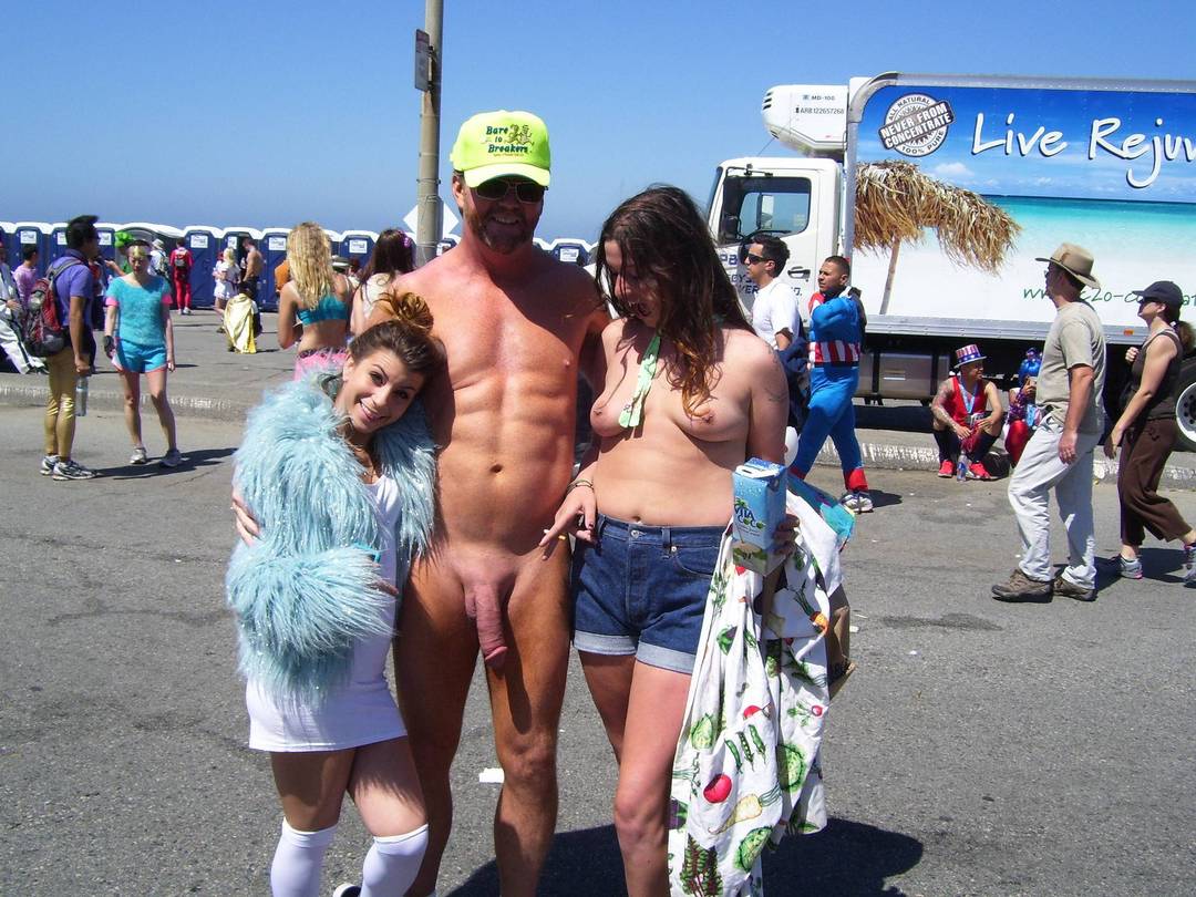 Hung white man posing nude with women in costumes at Bay to Breakers street fair, CFNM public exhibitionism