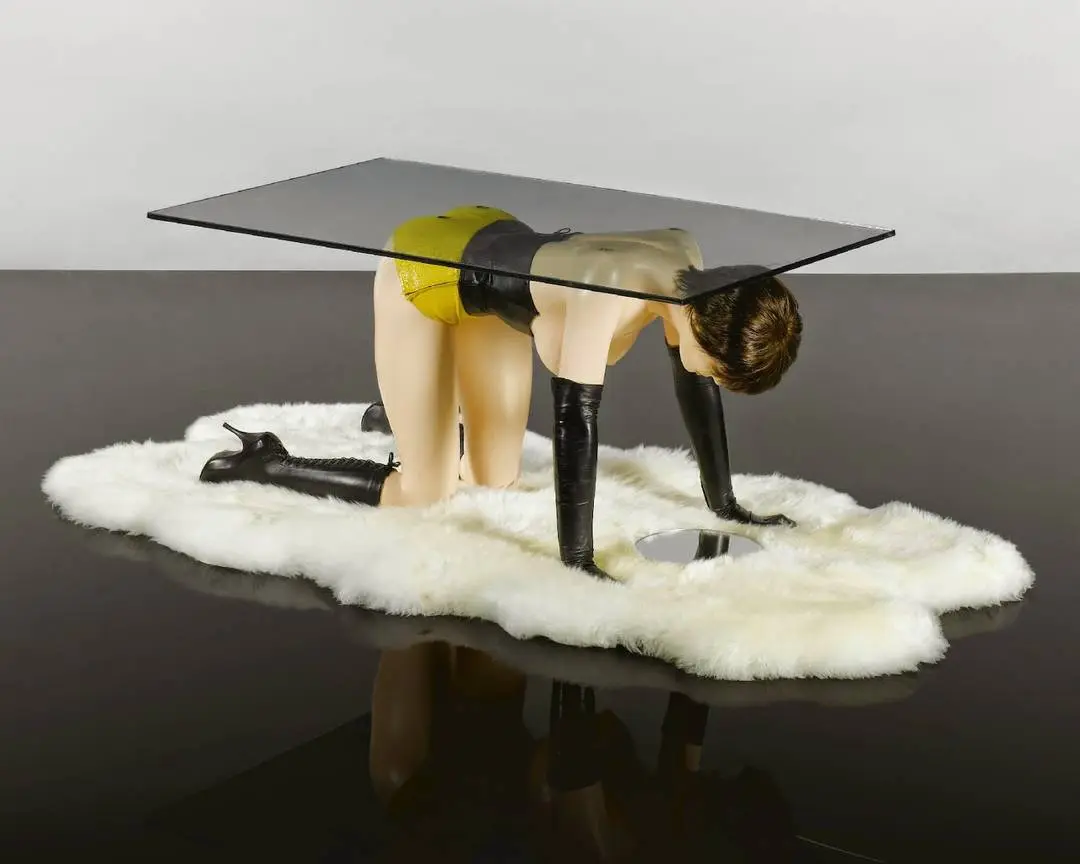 Allen Jones' 'Hatstand, Table and Chair' featuring blonde sex dolls in lingerie and boots on white faux-fur rugs.