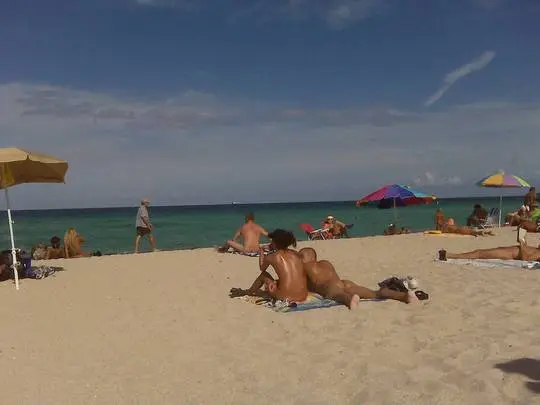 Naturists sunbathing and lounging on the sandy shores of Haulover Beach in North Miami, FL.