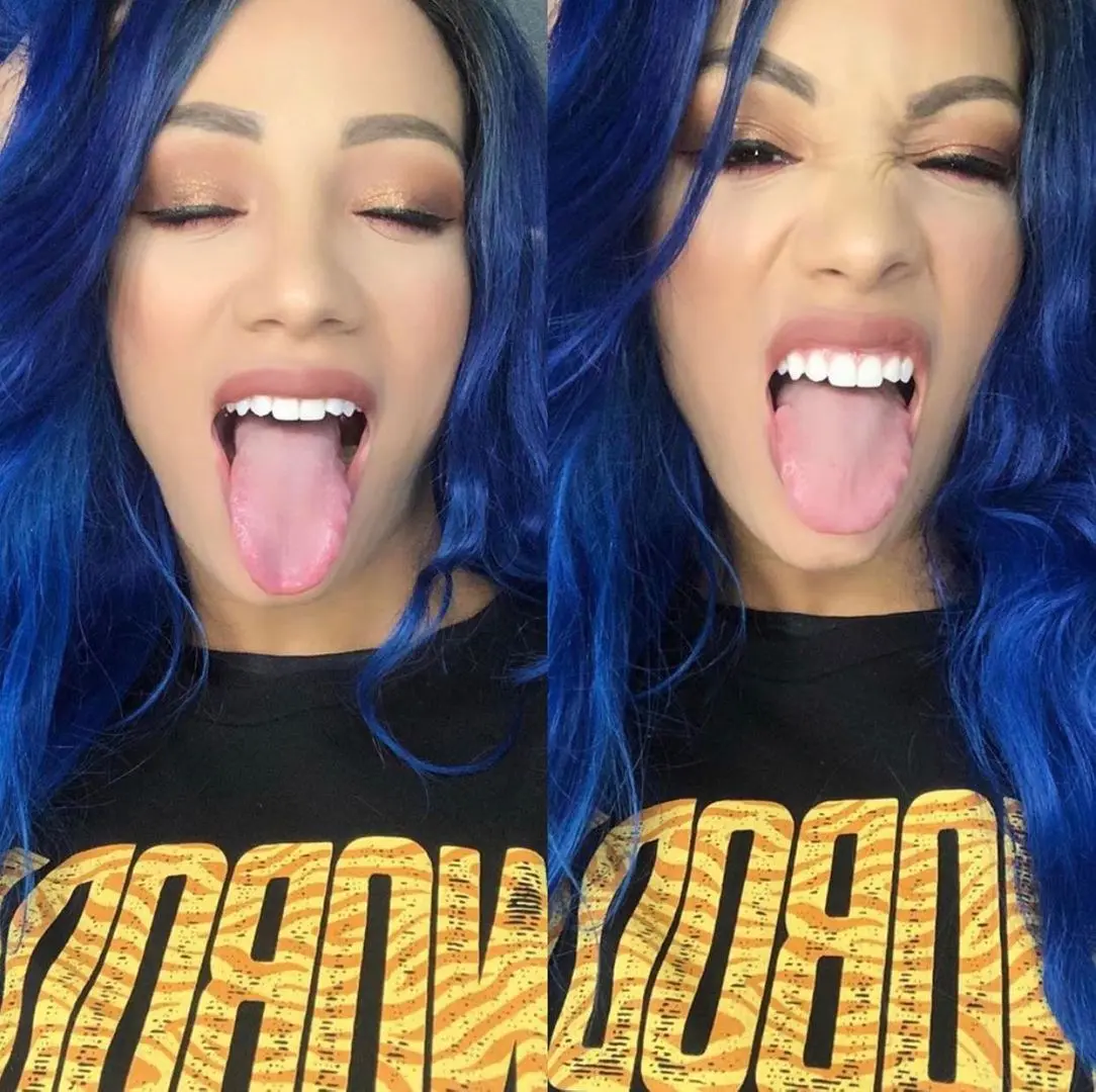 Mixed woman with long blue wavy hair sticking her tongue out in a selfie