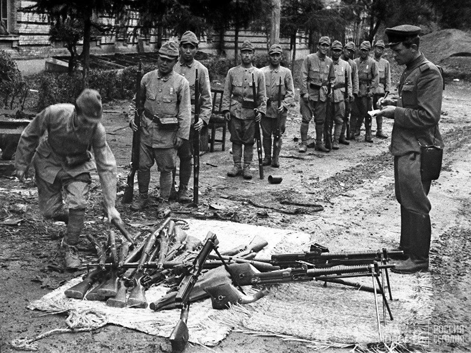 Japanese soldiers of the Kwantung Army hand over their weapons to a Soviet officer. Circa 22-24 of August 1945. Building on the background is Japanese HQ in Port Arthur.