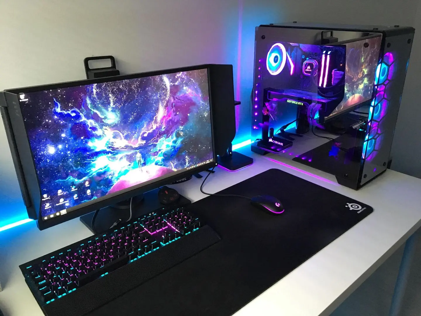 Cool gaming pc setup with a space desktop wallpaper, RGB lighting, and a mechanical keyboard on a large mousepad
