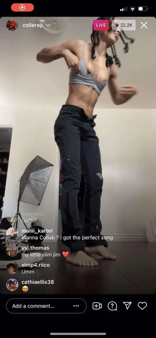 Coi Leray experiencing a nip slip while wearing a grey bralette and dark pants during a TikTok live stream.