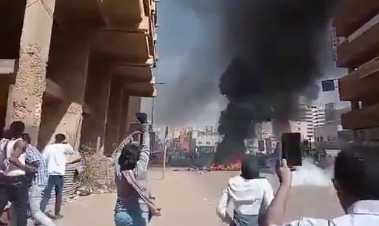 Picture of a female protester giving riot police the Sudanese ...