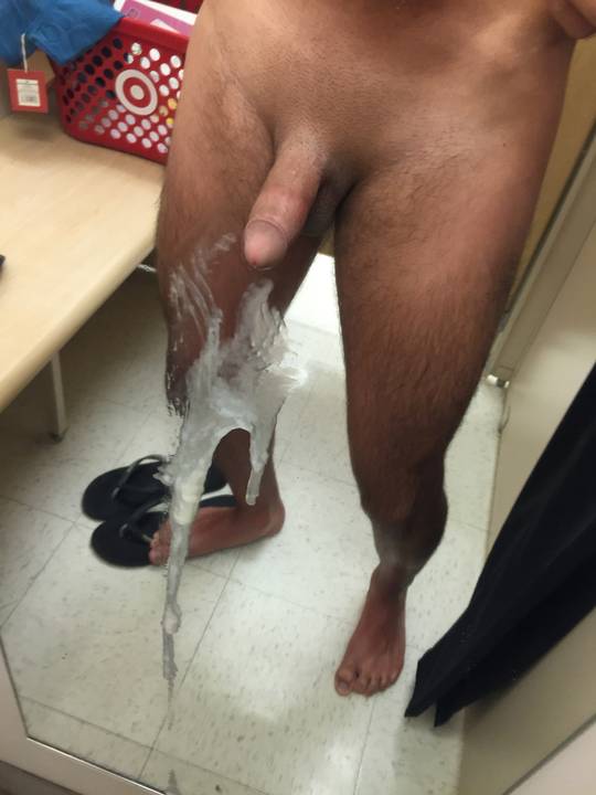 Athletic white man with pubic hair taking a naked selfie in a fitting room with cum on his thigh