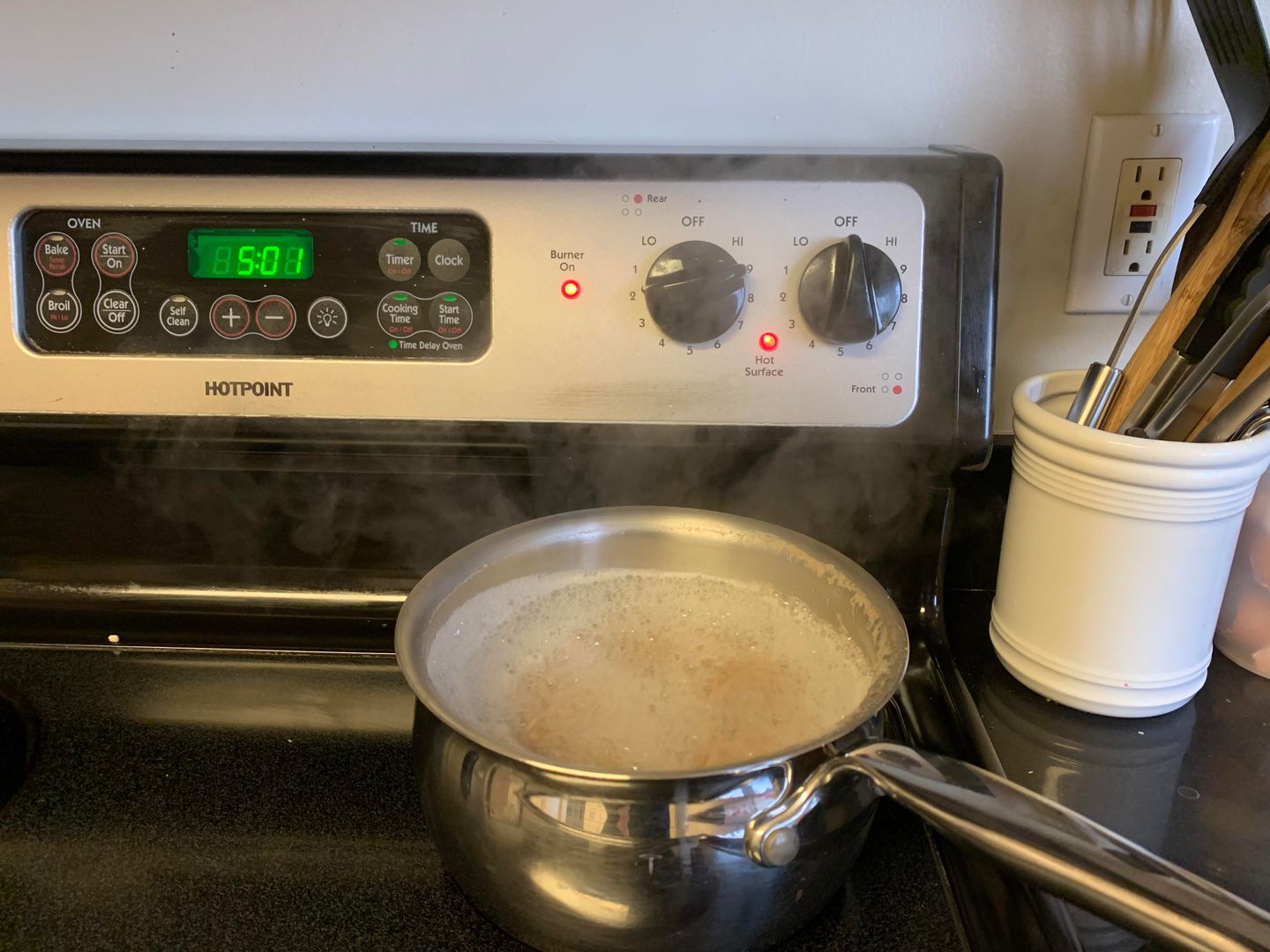 Reach through hot steam to turn down the heat