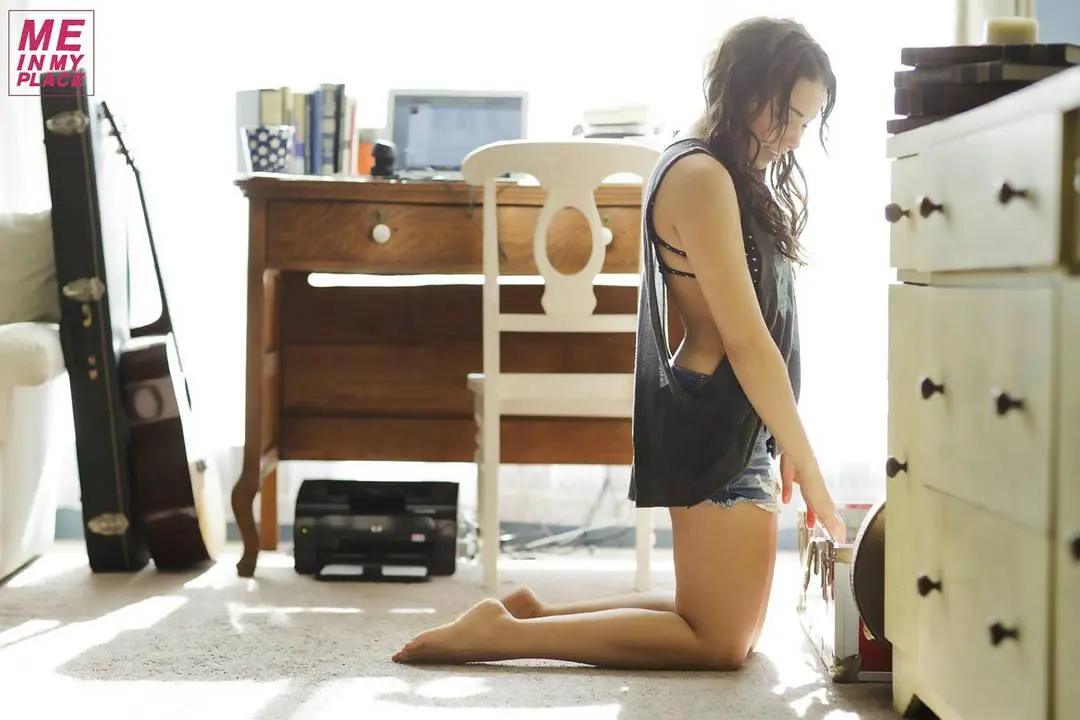 Jessica Parker Kenney in tank tops and denim shorts posing in a New York City living room and bathroom