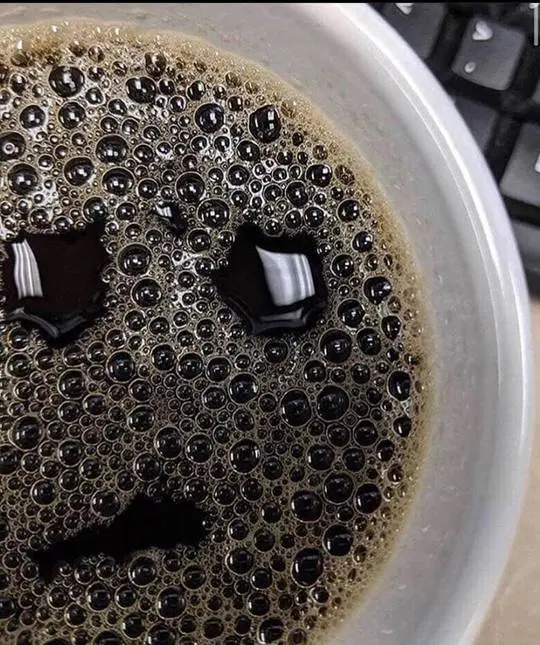 ADHD meme of black coffee in a white cup with bubbles forming a sad anthropomorphic face