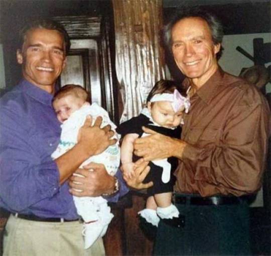 Arnold Schwarzenegger and Clint Eastwood holding Patrick and Francesca in 1993