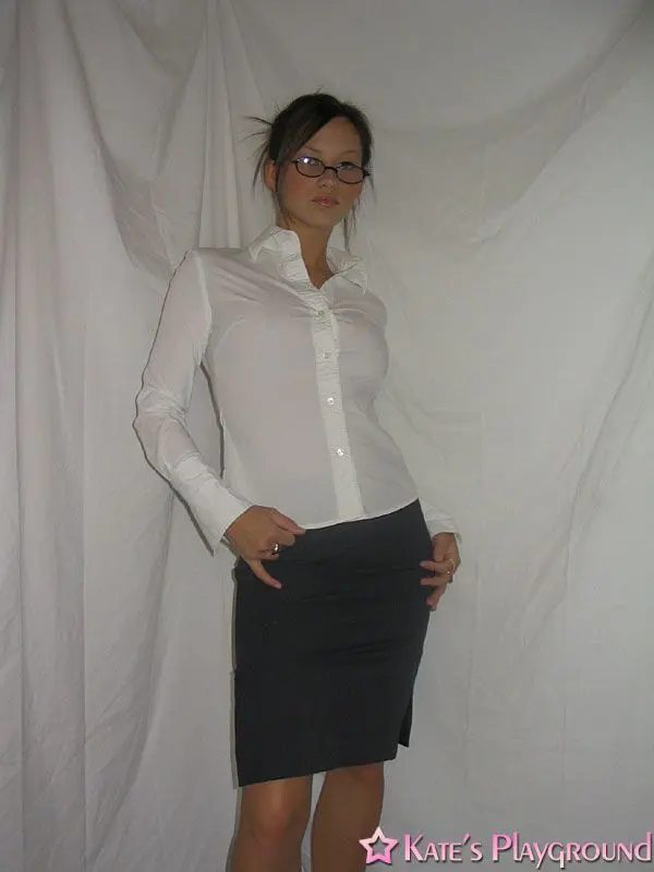 Kate in a sexy teacher outfit featuring a white blouse, tight grey pencil skirt, and glasses