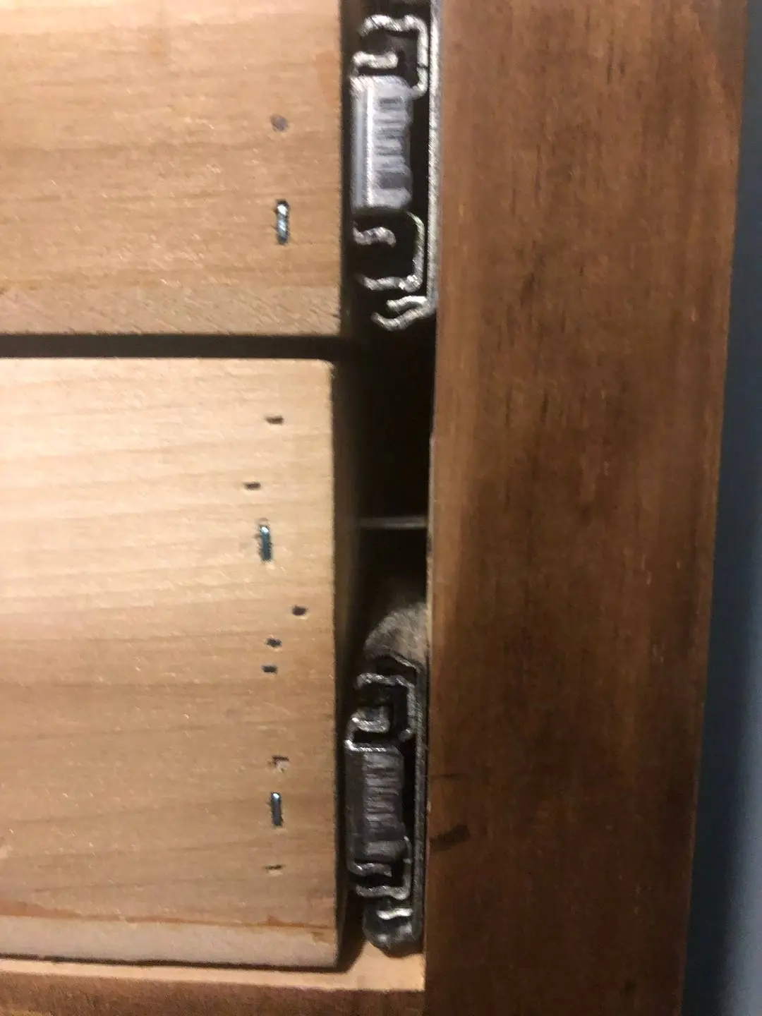 Sex toys including dildos, vibrators, and anal beads organized in a wooden dresser drawer