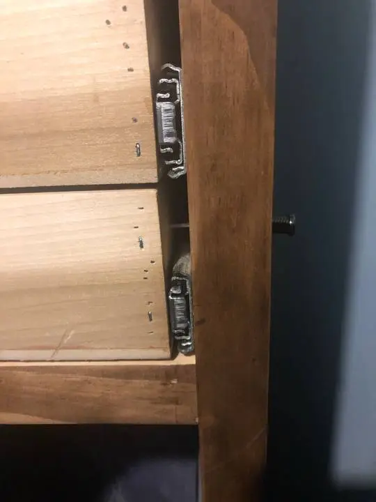 Sex toys including dildos, vibrators, and anal beads organized in a wooden dresser drawer