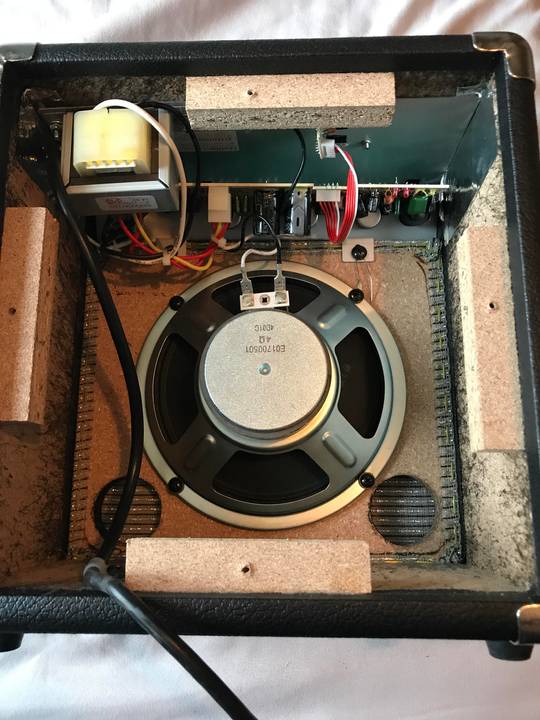 The inside of a small fender electric guitar speaker.